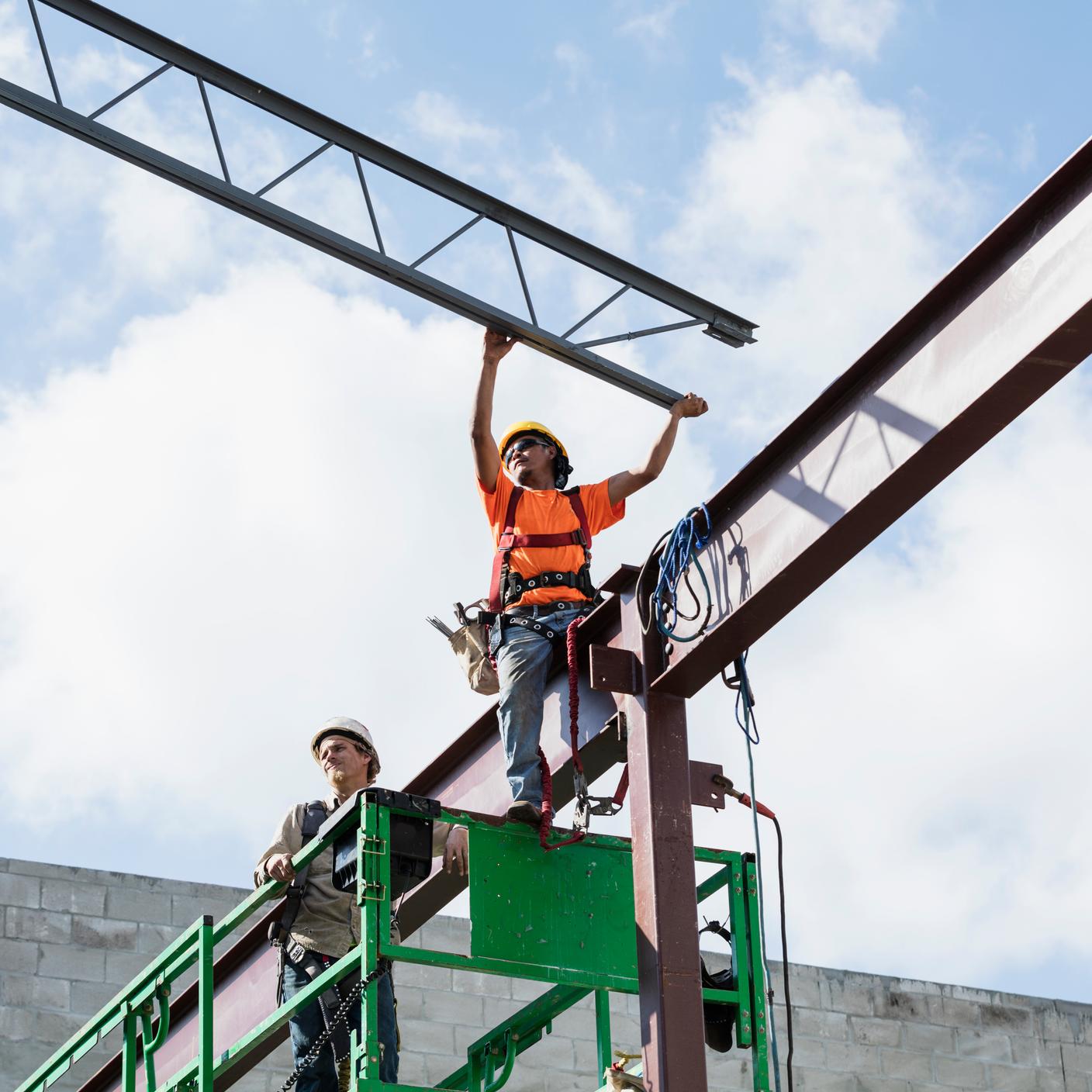 Two construction workers on a scissor lift