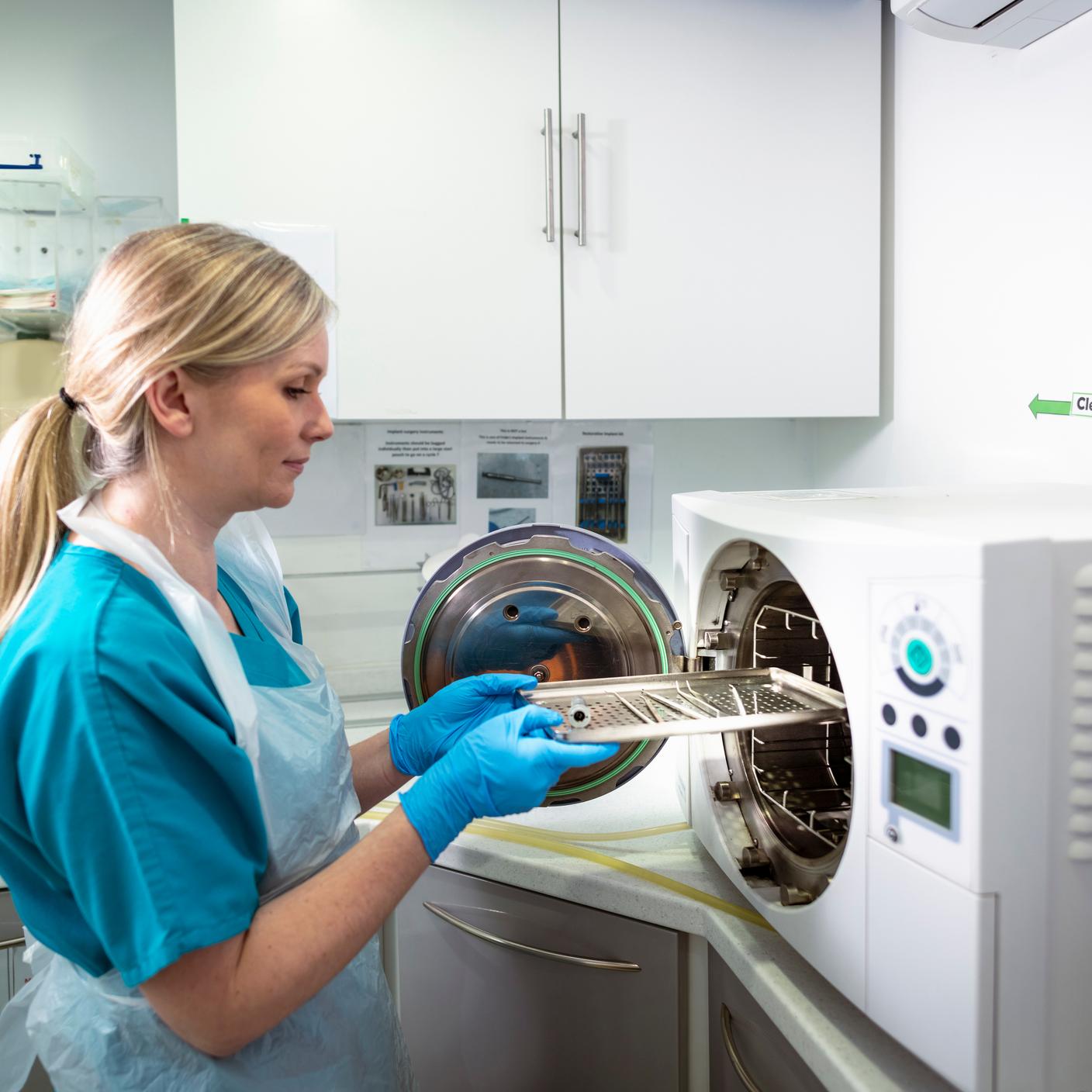 Medical staff sterilizing equipment in a sterilization machine