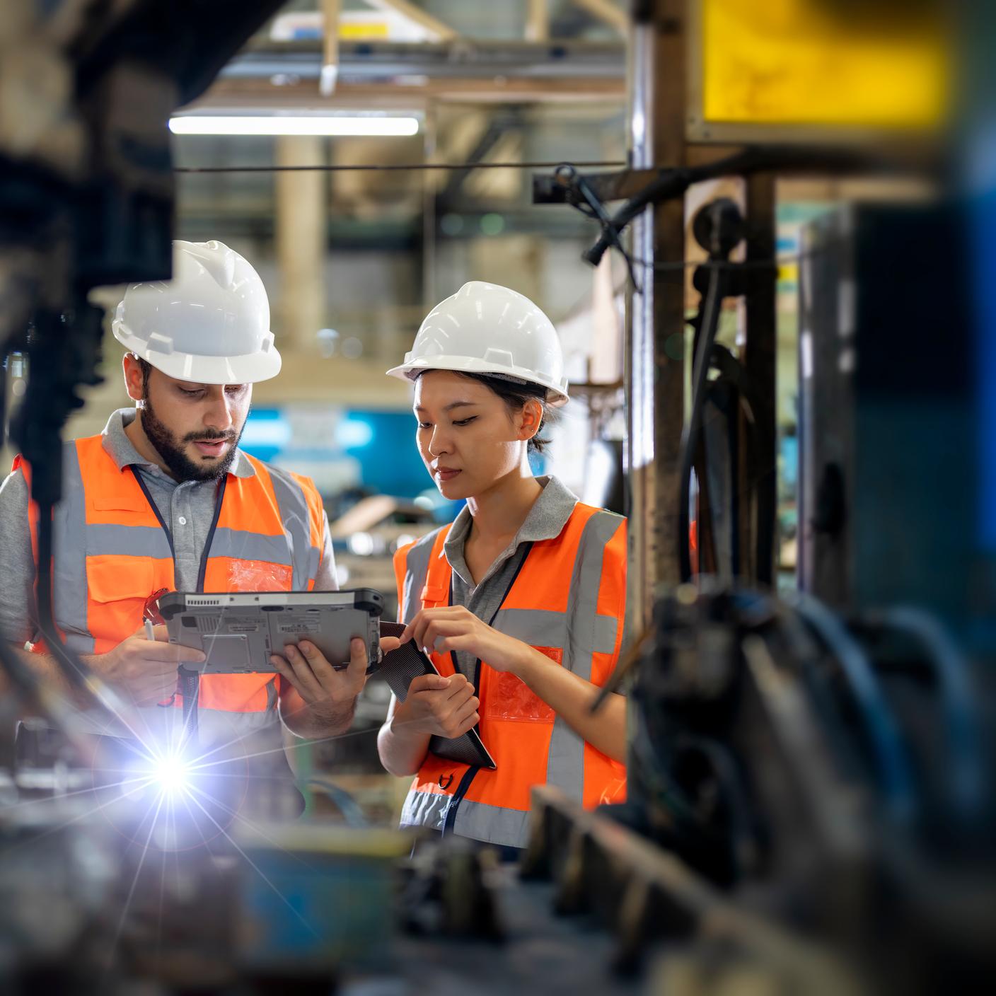 Engineers observing the Robotics arm welding units operating at factory. Improve Manufacturing Productivity and Quality Control Concept. Robotic Process Automation for Auto Part manufacturing Industry.