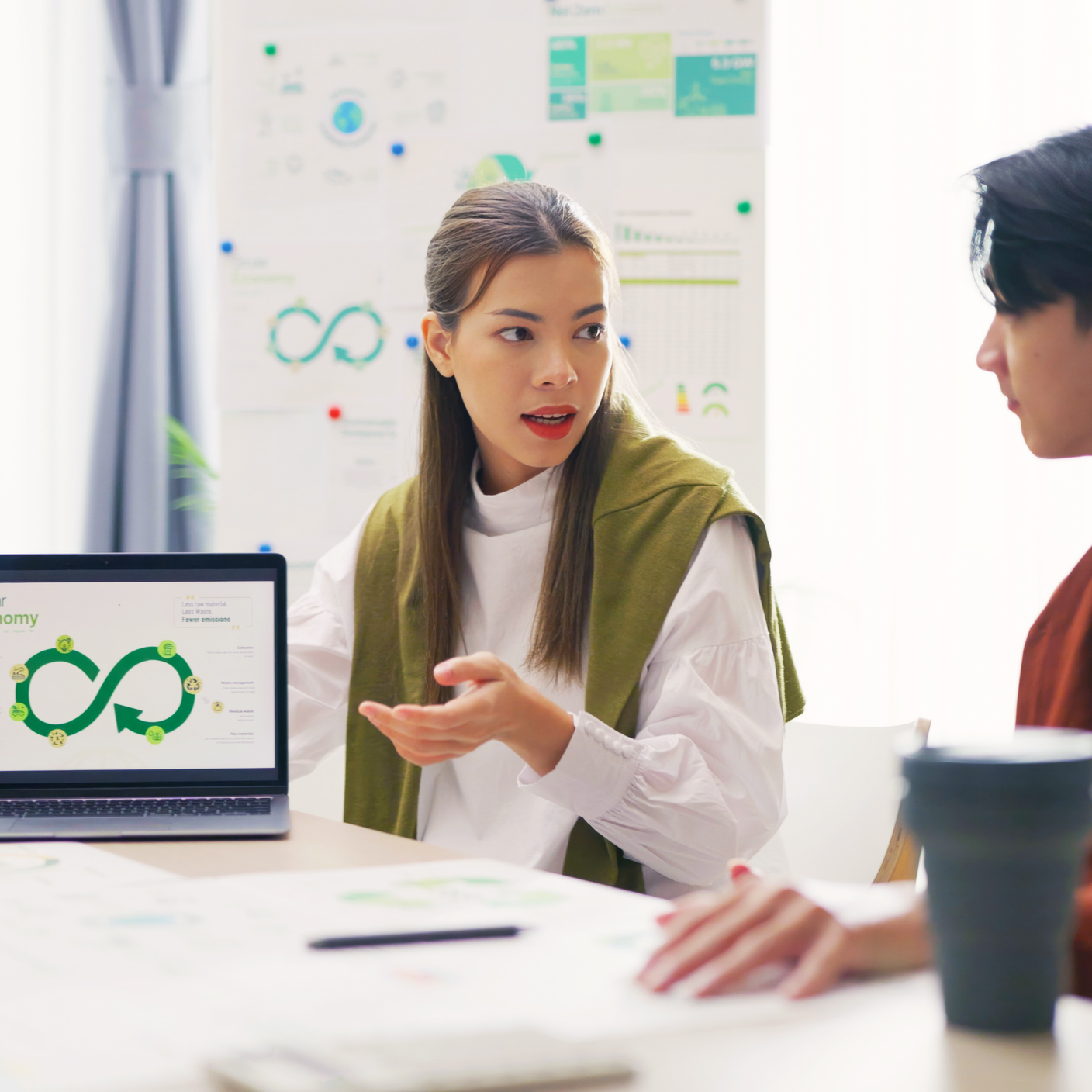 A team of professionals, including strategies using a laptop presentation in a bright office.a focused woman, discuss