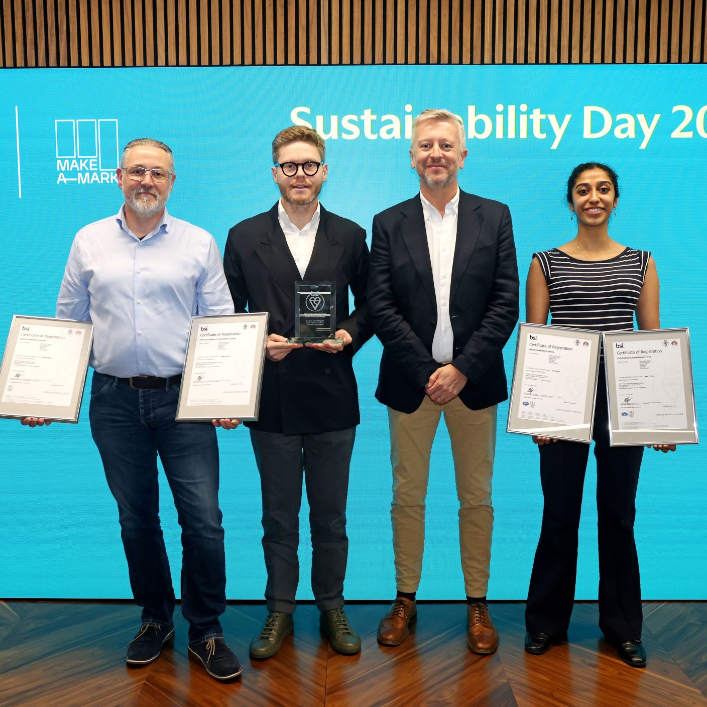 Four people holding Aston Martin Certifications