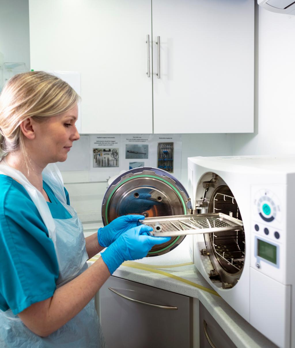 compliance management - dental nurse sterilizing dental equipment