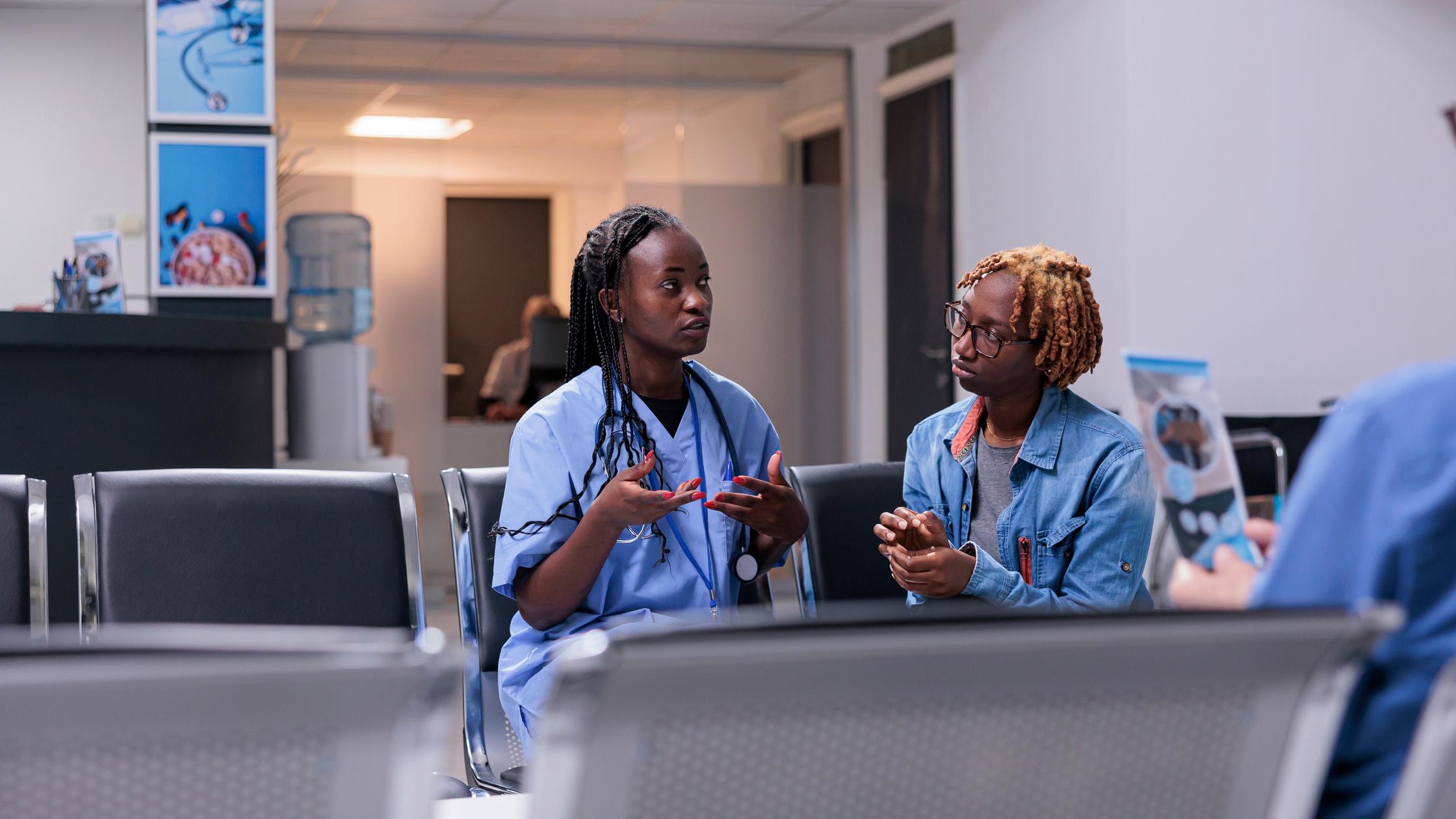 Medical assistant consulting woman at clinic